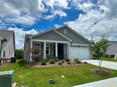 Craftsman inspired home featuring a porch, a front yard, driveway, an attached garage, and board and batten siding