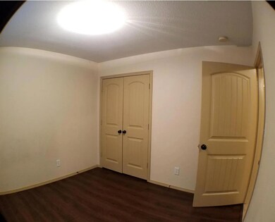 Unfurnished bedroom with a closet and dark wood-ty