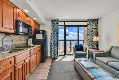 Kitchen with open floor plan, light stone counters