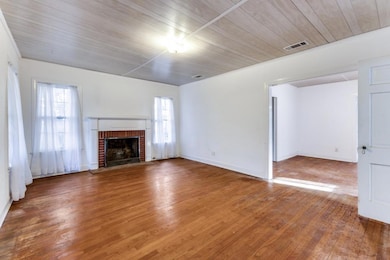 Unfurnished living room with visible vents, baseb