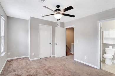 Unfurnished bedroom with carpet flooring, connected bathroom, ceiling fan, and a closet