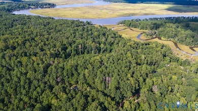 Aerial view of property and surrounding area with a heavily wooded area