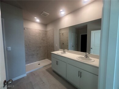In suite Bathroom with double vanity, tiled shower