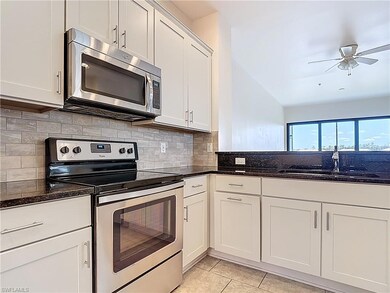 Kitchen featuring a sink, dark stone counters, dec