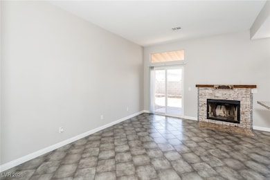 Unfurnished living room with baseboards and a fire