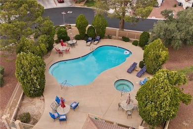 Community pool with a patio and a hot tub