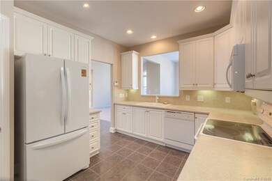 White kitchen with gray tiled floors and pass thru