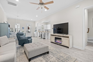 Living room with crown molding, light hardwood / w