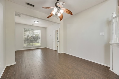 Spare room featuring dark wood finished floors, a textured ceiling, and ceiling fan