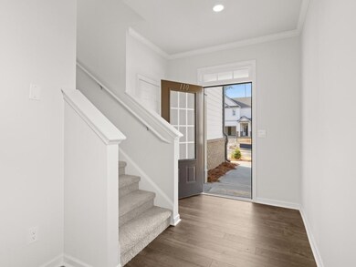 Elston front entryway into home with a coat closet and access to staircase with carpet