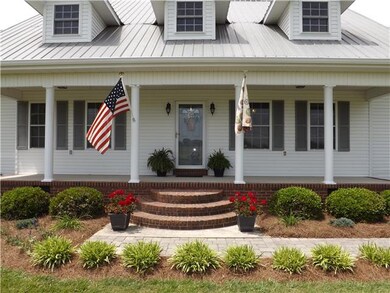 Relaxing front porch with stone sidewalk leading to concrete driveway
