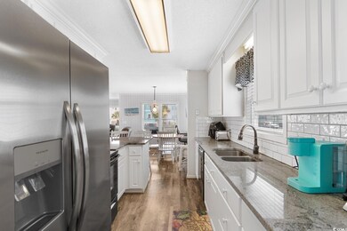 Kitchen with white cabinetry, hardwood / wood-styl