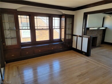 Spare room with crown molding, light wood-type flooring, and a fireplace