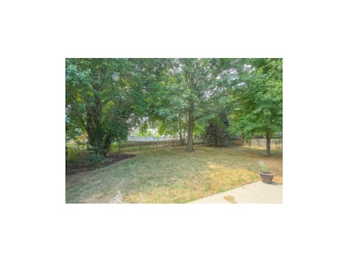 Large fenced and treed backyard with patio.