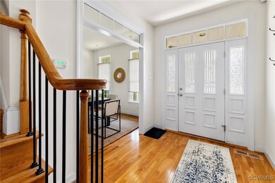 Foyer entrance with baseboards, visible vents, woo