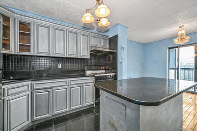 Kitchen featuring pendant lighting, a center island, dark stone countertops, decorative backsplash, and under cabinet range hood