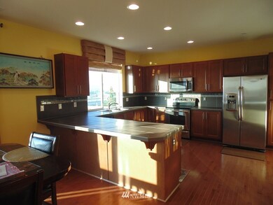 Open Concept Kitchen with Stainless Steel Appliances with beautiful Tile backsplash. Lots of Cabinets and Counter space. 