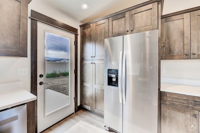 Kitchen with appliances with stainless steel finishes, light countertops, recessed lighting, light wood-type flooring, and dark brown cabinetry