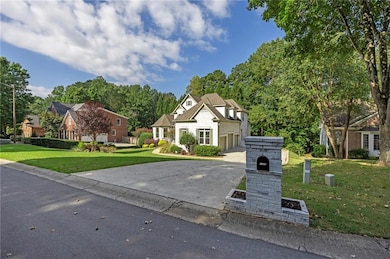 French provincial home with a front yard, driveway, and a garage