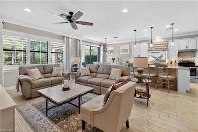 Living area with crown molding, recessed lighting, light wood-type flooring, and a ceiling fan