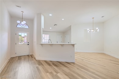 Foyer entrance featuring a chandelier, light wood-