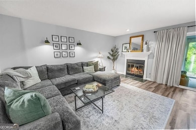 Living room with wood finished floors and a glass covered fireplace