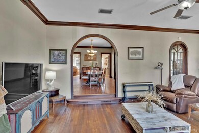 Living room featuring ornamental molding, hardwood