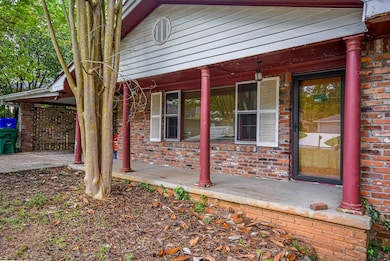 Property entrance featuring brick siding and a por