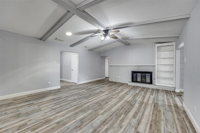 Unfurnished living room featuring lofted ceiling w