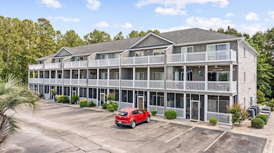 View of building exterior with uncovered parking