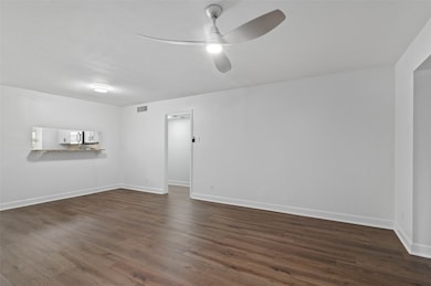 Living area with new flooring and paint and a pass-through window to the kitchen.