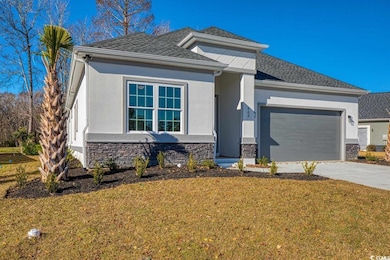 View of front of house with stone siding, an attached garage, stucco siding, a front lawn, and concrete driveway