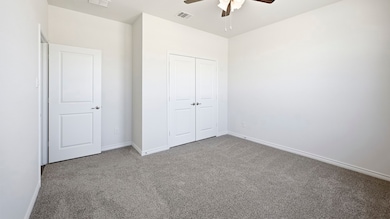 Unfurnished bedroom with carpet, a closet, and a ceiling fan
