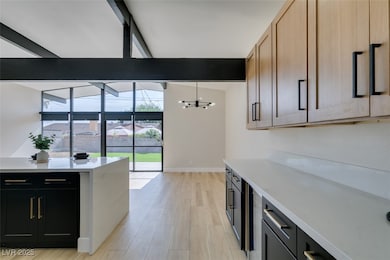 Kitchen featuring light countertops, a chandelier,