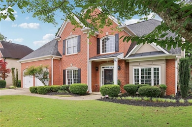 Traditional-style home with brick siding, an attached garage, and a shingled roof