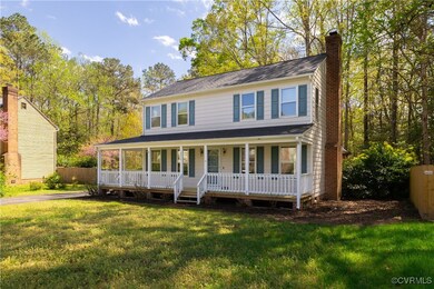 Colonial home featuring a front yard, a porch, fen