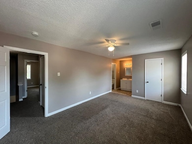 Unfurnished bedroom with ensuite bath, a textured 