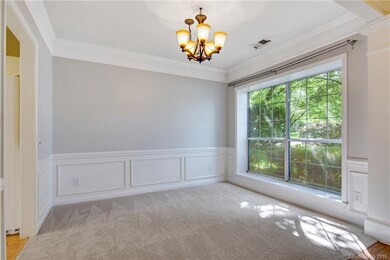 Formal dining room with wainscoting and large pict