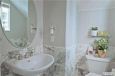 Powder room with marble floor and wainscoting.