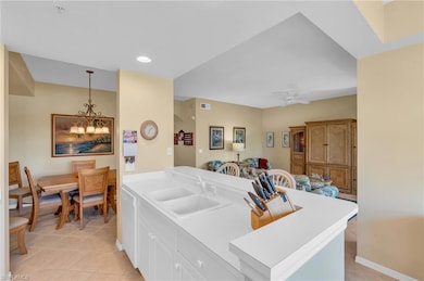 Kitchen featuring white cabinetry, sink, hanging l