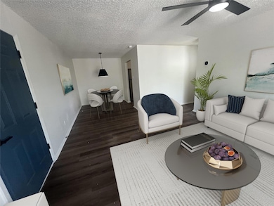 Living room featuring baseboards, a textured ceili