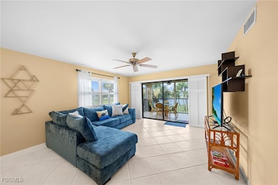 Living room with light tile patterned floors and ceiling fan