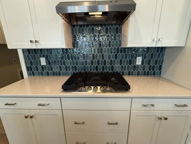 Kitchen with decorative backsplash, white cabinetr