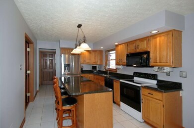 This spacious kitchen features beautiful dark gran