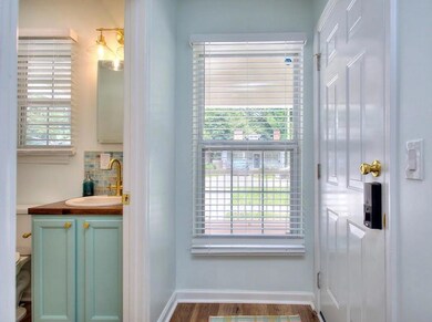Bathroom featuring vanity, baseboards, plenty of natural light, and wood finished floors
