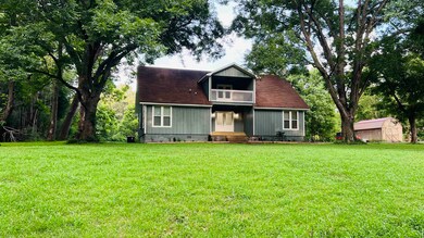 View of front facade featuring a balcony, a front lawn, and crawl space