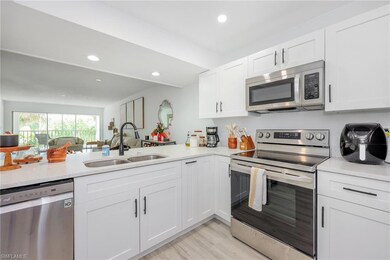 Kitchen featuring white cabinetry, light counterto