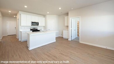 Kitchen with white cabinetry, an island with sink, recessed lighting, light countertops, and light wood-style floors
