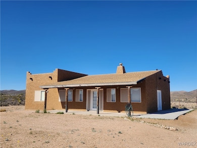 View of front facade with a patio, a chimney, a mo