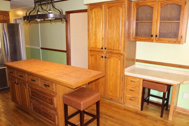 Kitchen has Island w/ bar and cabinet storage, Pantry, and work desk